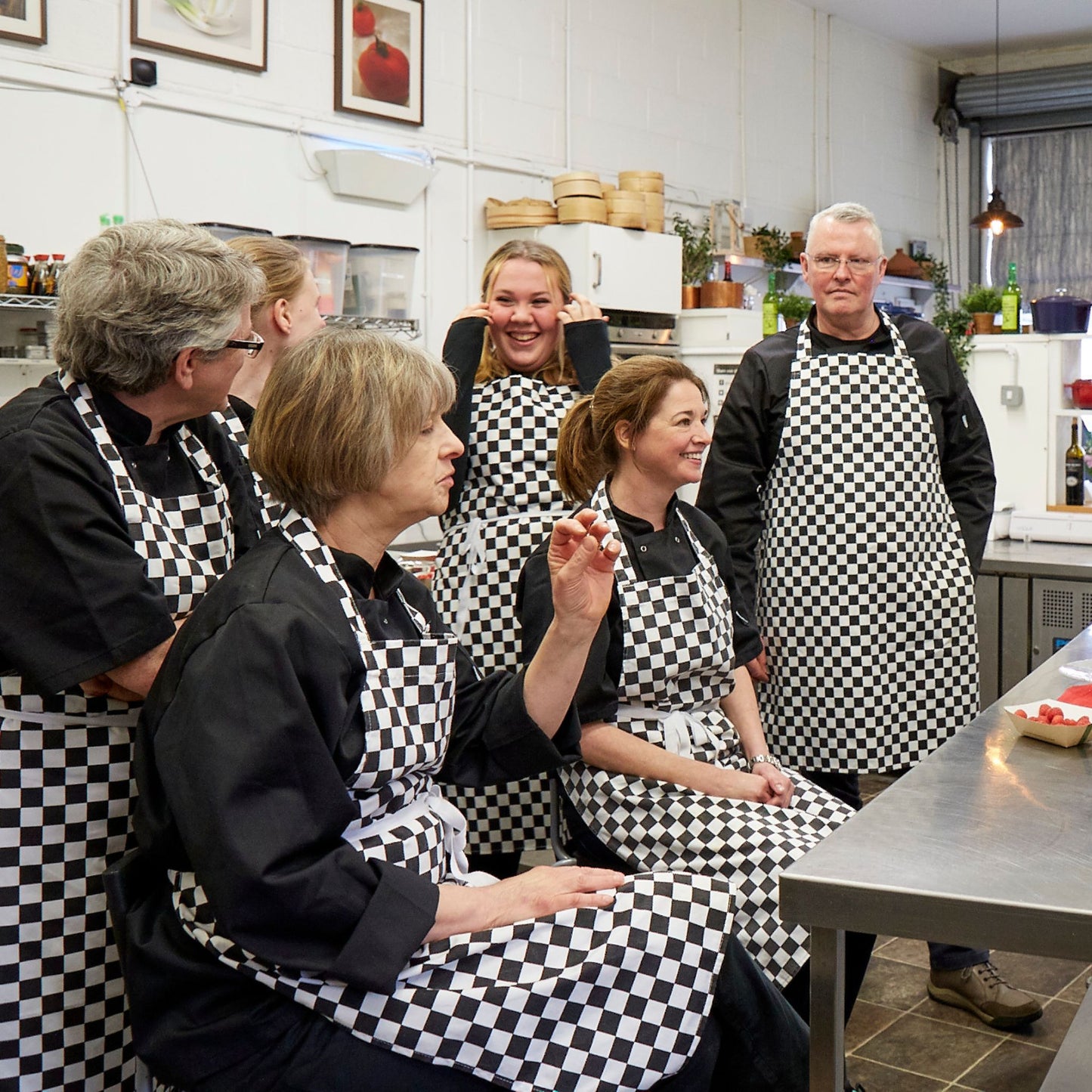 A group of professional course students listening to a chef talking