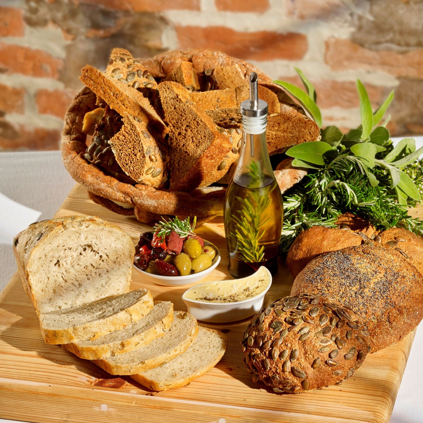 Different types of bread, olive oil, butter, olives, herbs