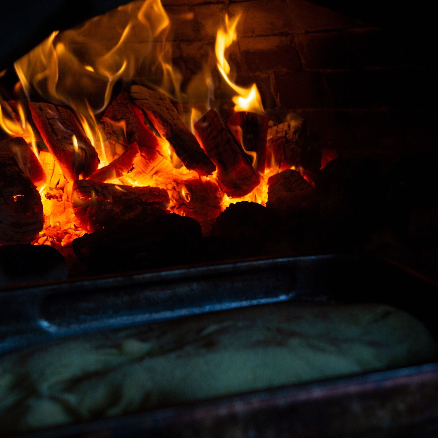 Wood burning in an oven with bread baking