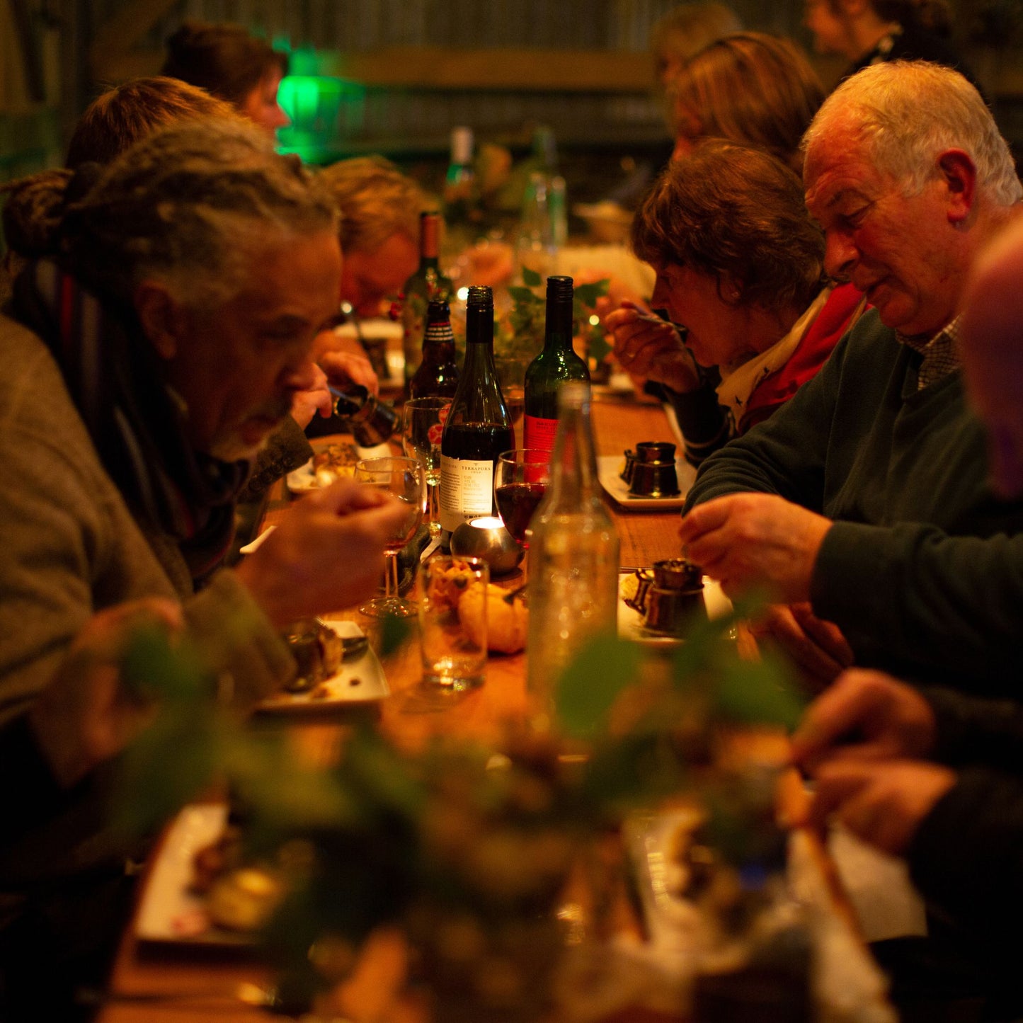 Men and women sitting at a long table and eating