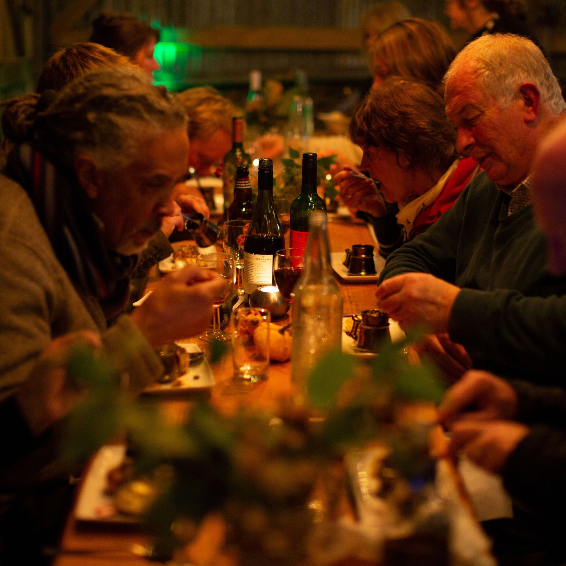 Men and women sitting at a long table and eating