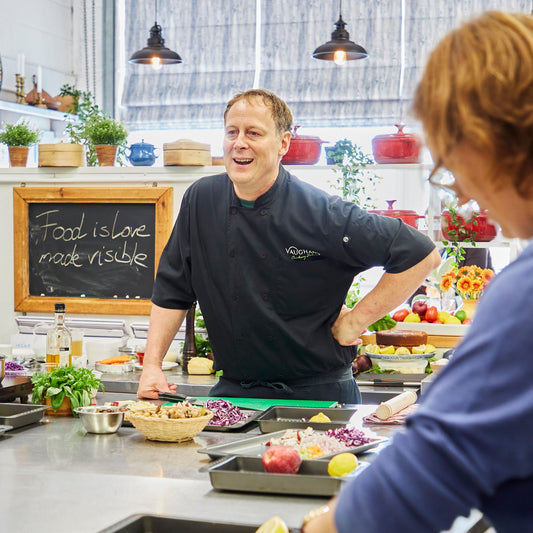 Chef talking to cookery students with Indian ingredients on the table