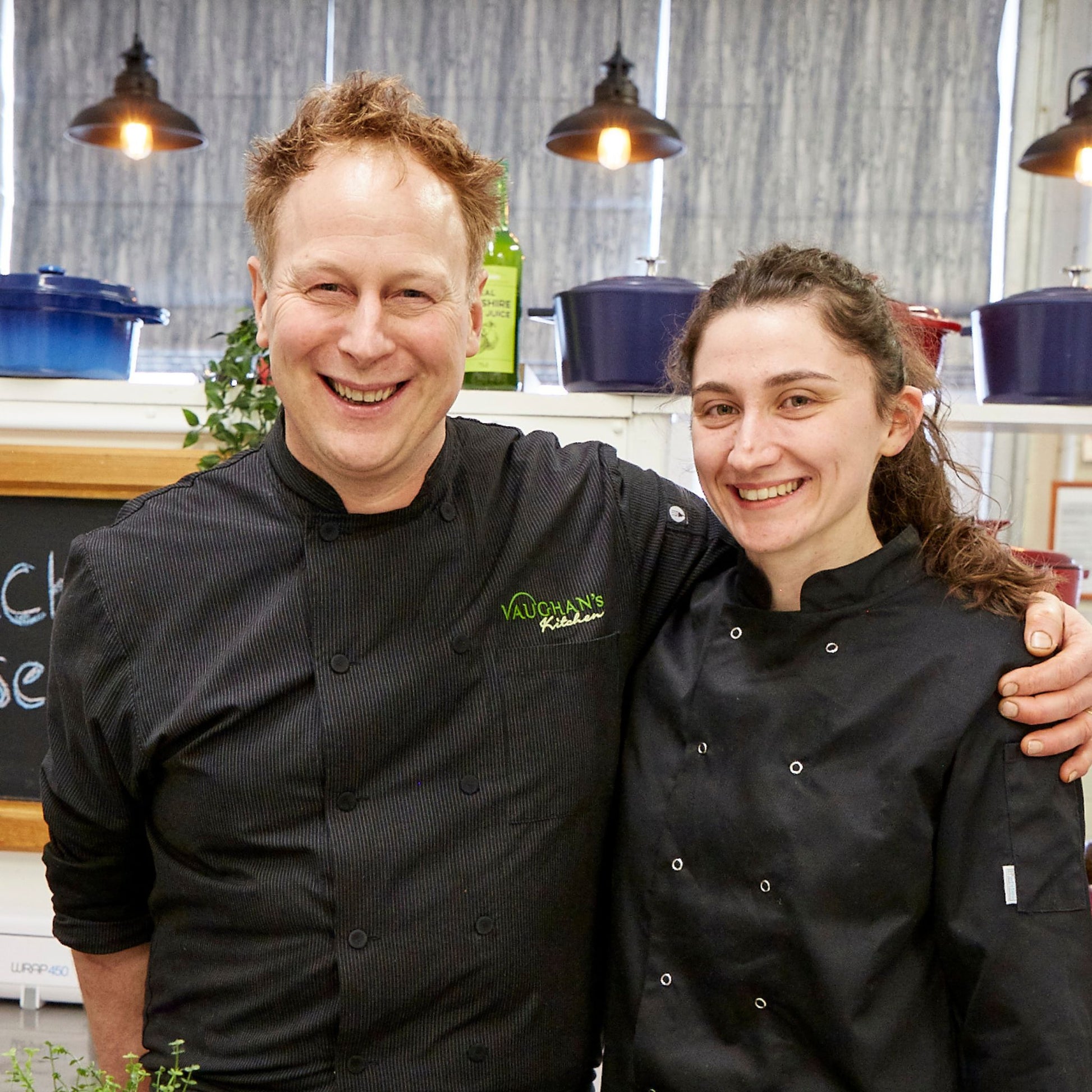 Chef Peter Vaughan standing with chef Aimee in the kitchen