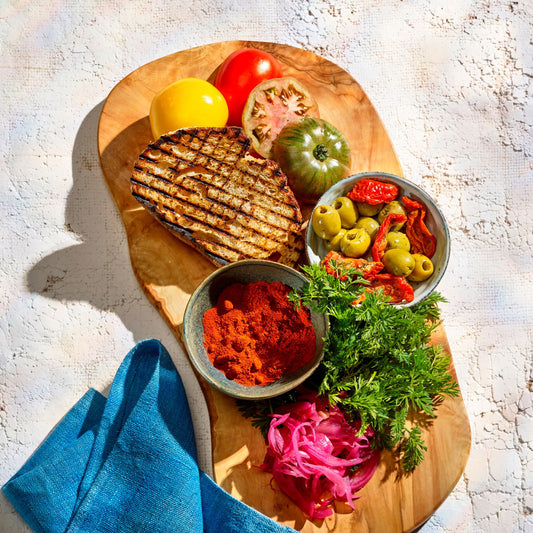 Olive wood board of Spanish tapas dishes & spices