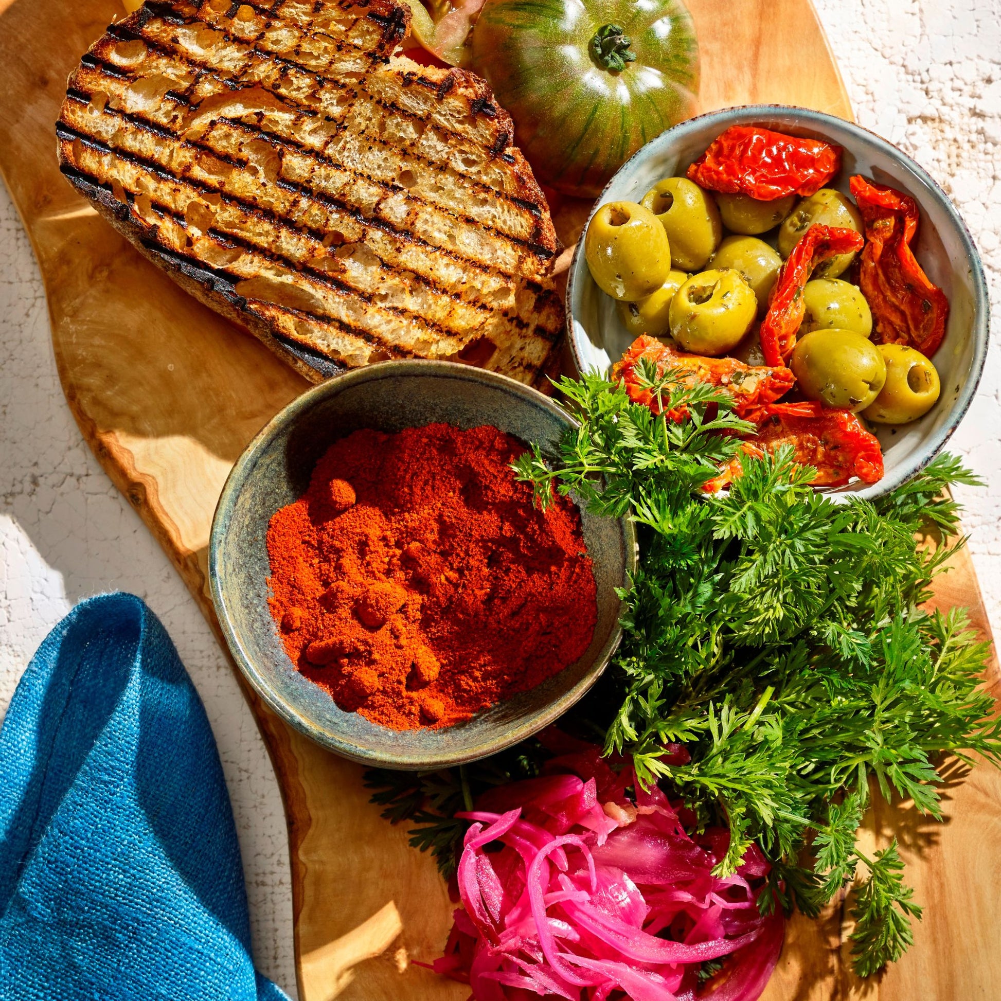 Close up of Spanish food in small pots of olives, tomatoes, slice of bread