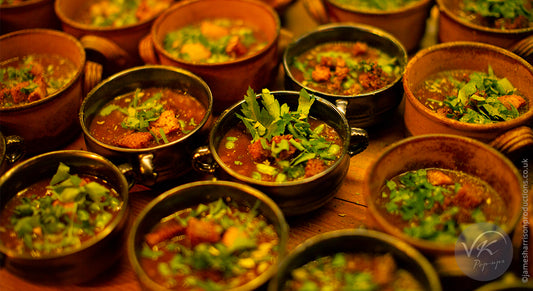 Brown bowl of soup & parsley lined up a wooden surface