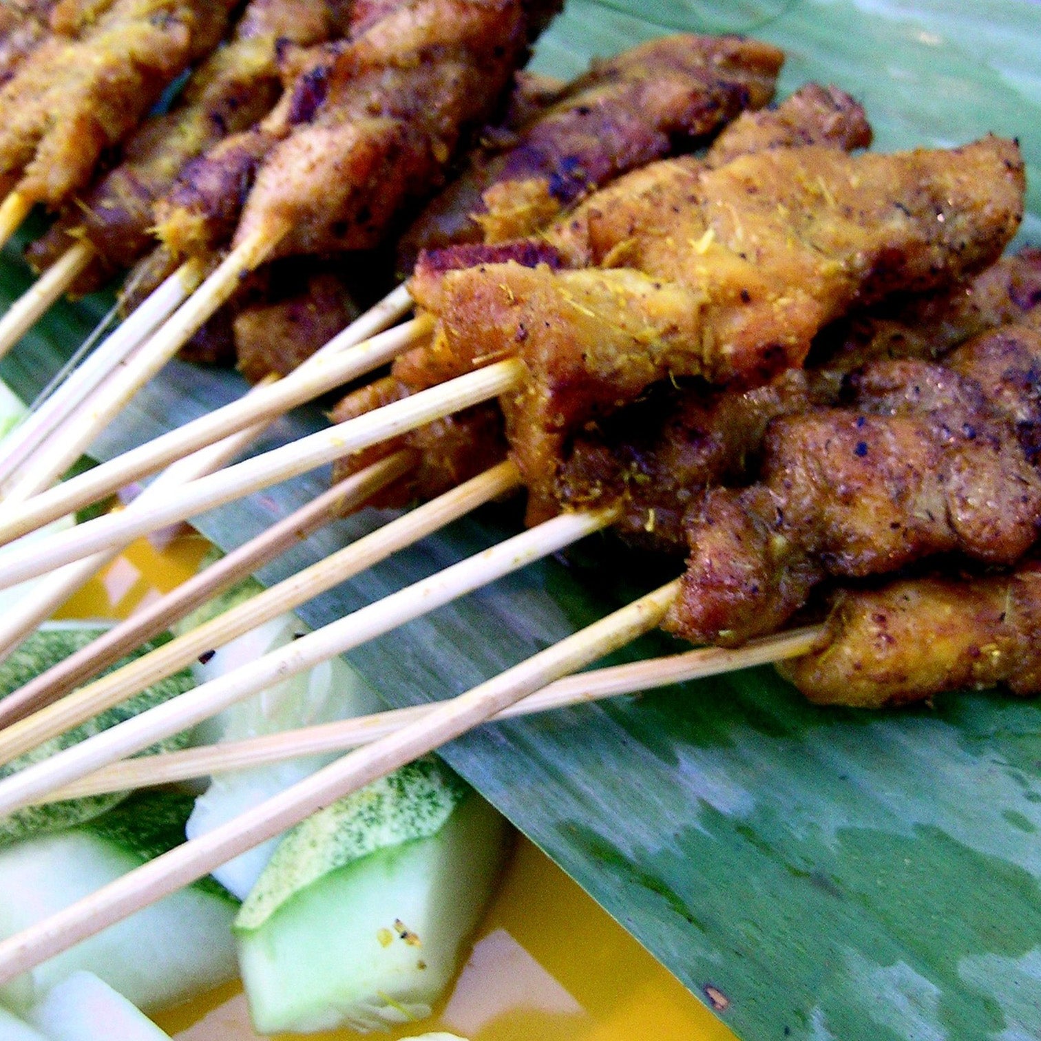 Thai satay on skewers on a green leaf plate