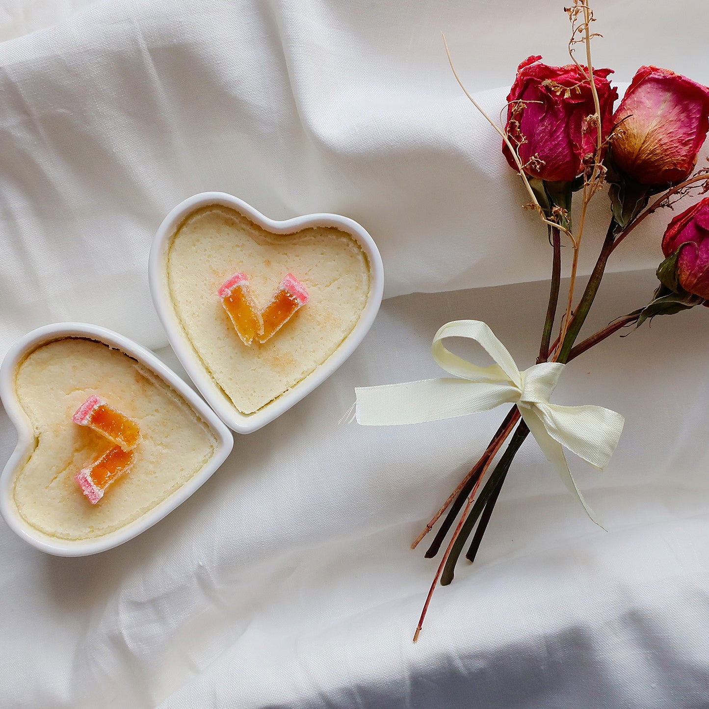 Valentine's dessert in heart dishes with a small bunch of dried roses