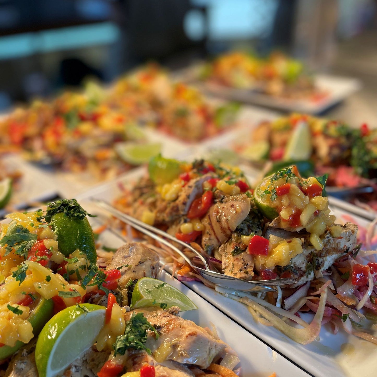 White platters loaded with Barbados slaw, mango & chilli, lime wedges