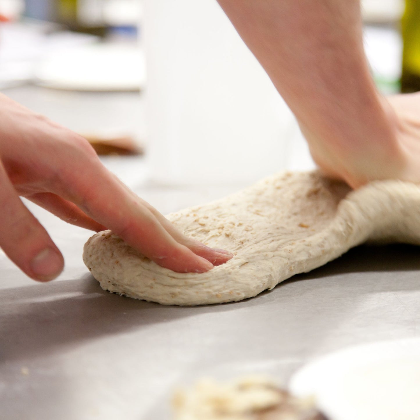 Hands stretching bread dough