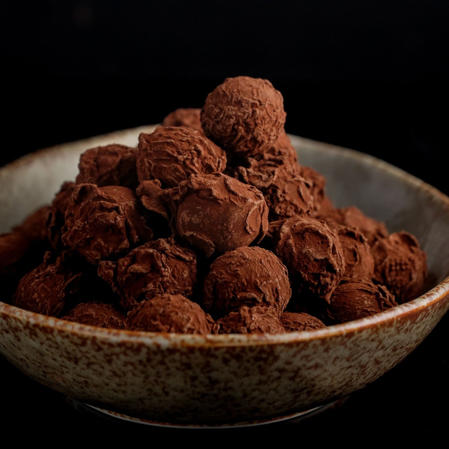 Handmade chocolate truffles in a rustic bowl