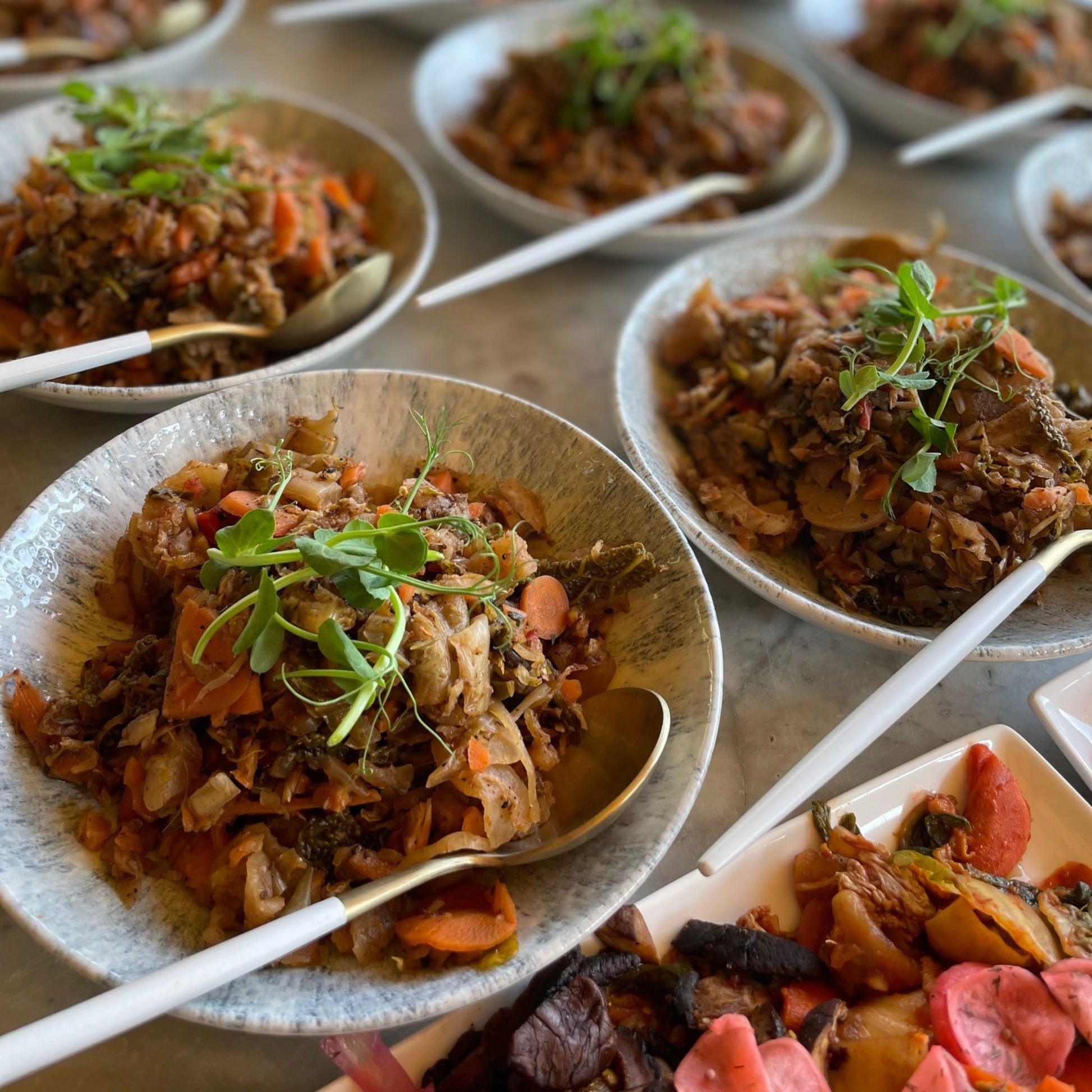 Bowls of fermented kimchi on a marble table