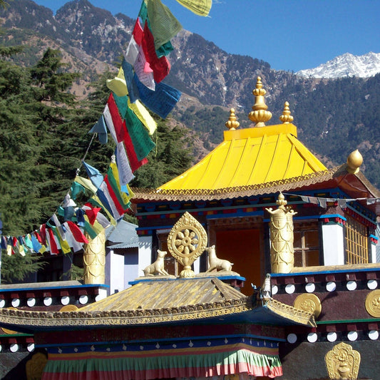 Buddhist temple at the foot of a mountain with prayer flags