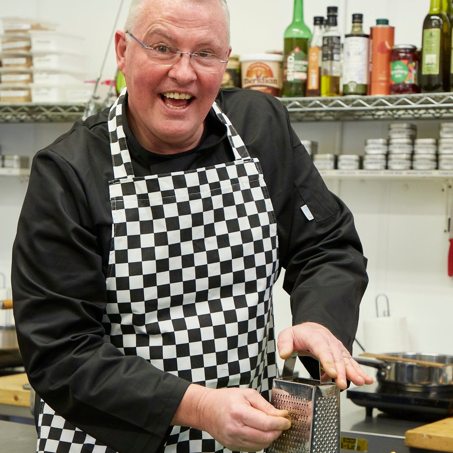 Middle aged man grating nutmeg in a kitchen