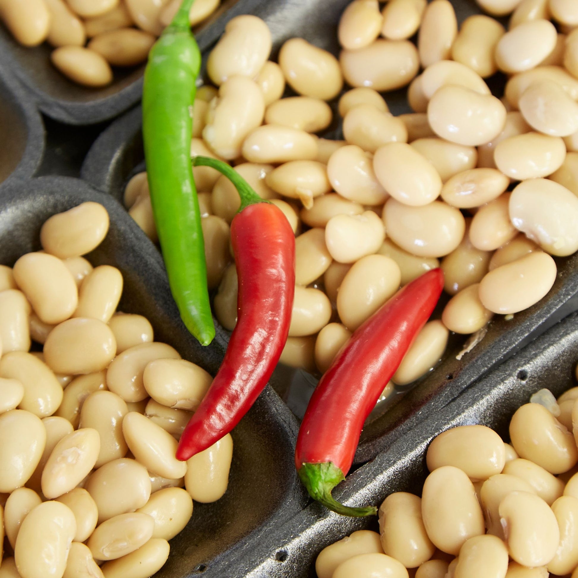 Dishes of beans with red and green chillies